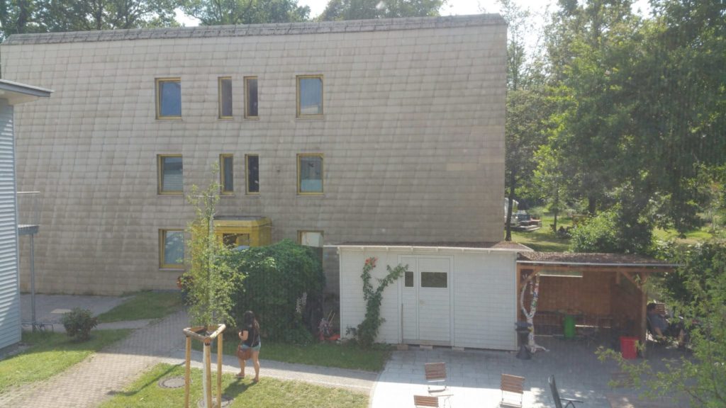 Fensterblick auf Garten und Appartementhaus